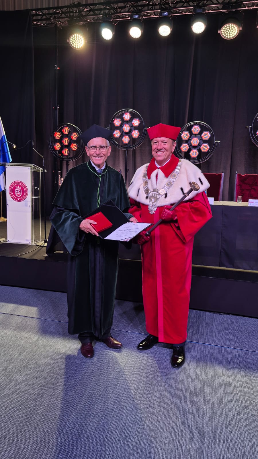 Zdjęcie w togach od lewej prof. Jan Wiktor i prof. Bernard Ziębicki z medalem w tle podium